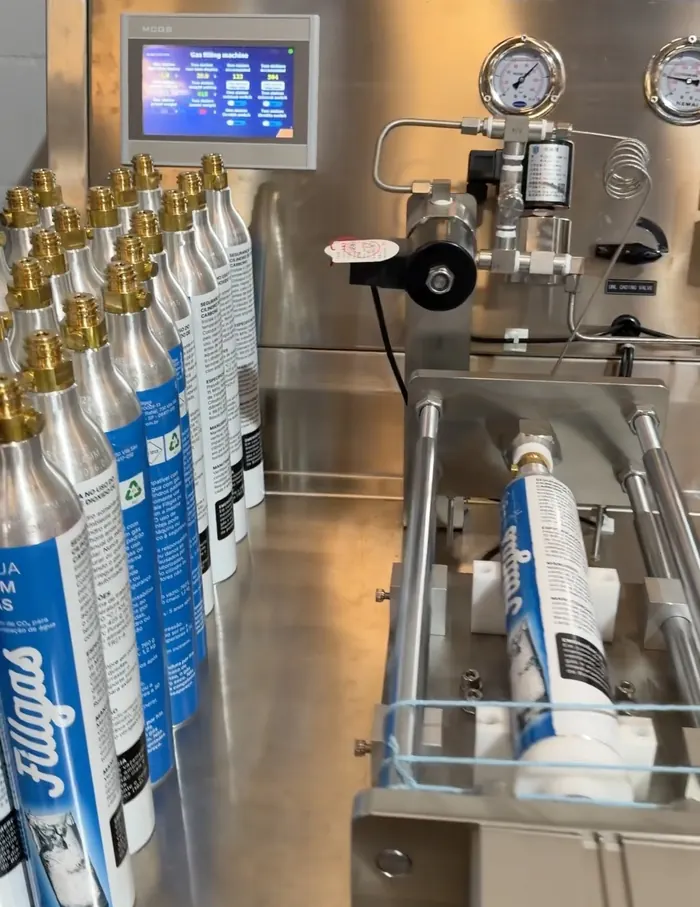 Estação de recarga de CO₂ com cilindros Fillgas enfileirados e um cilindro travado no berço de enchimento